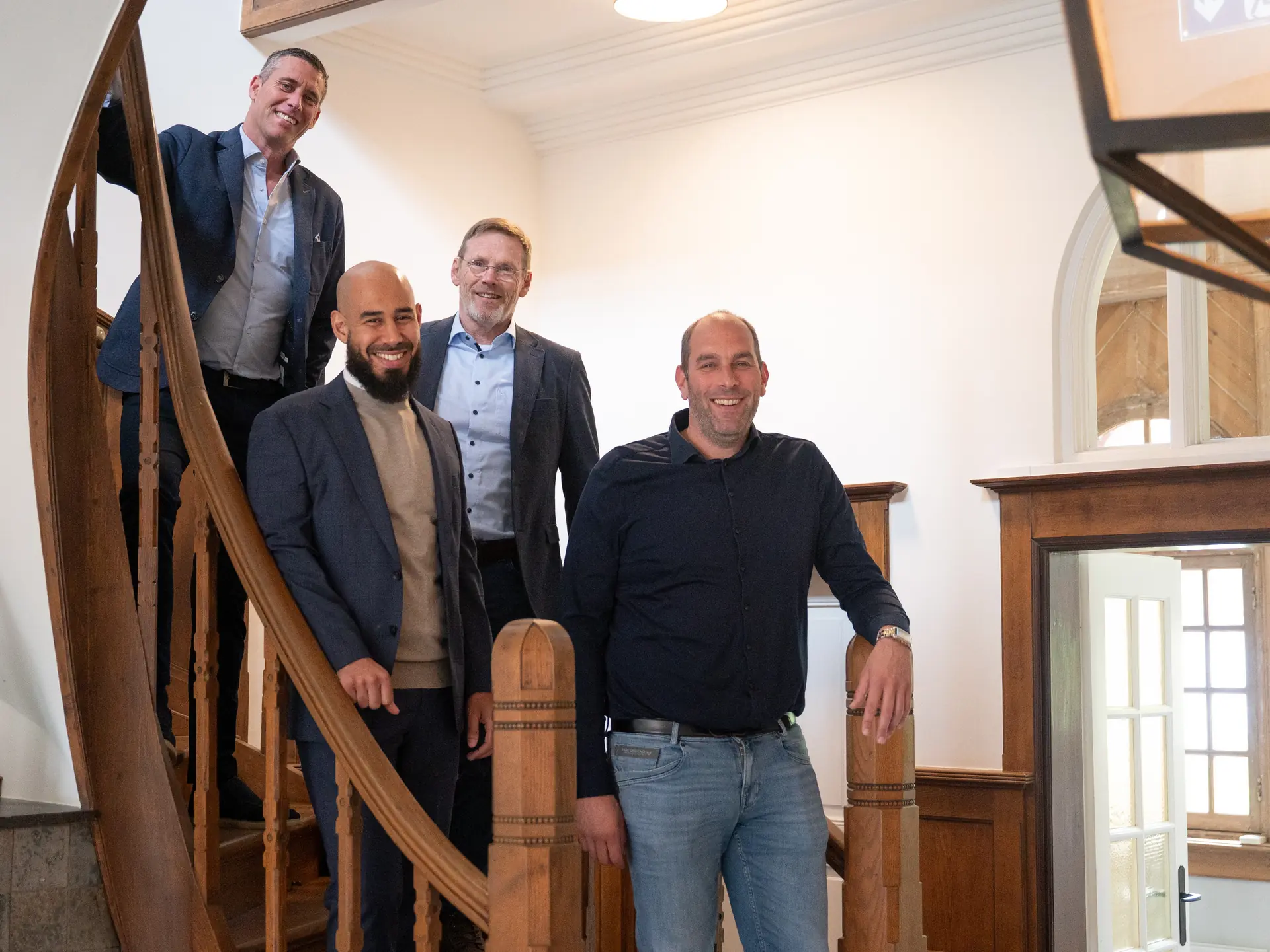 Het team van Schade Experts samen op de trap van het kantoor